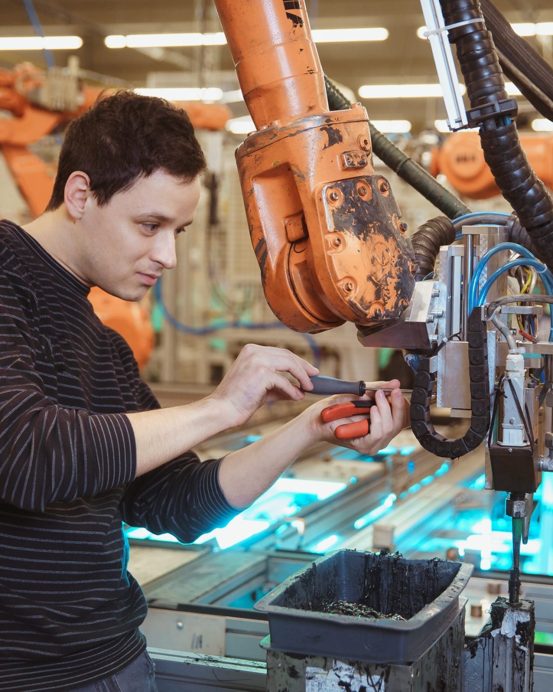 technical-worker-performs-maintenance-robotic-arms-on-the-production-line.jpg